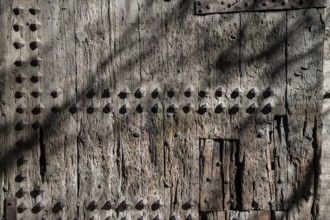 An old wooden door with visible wear and decorative nails