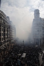 Dense crowds through a foggy city street MascletÃ¡ de Fallas
