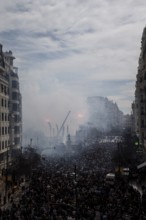 Large gathering of people in a smoky cityscape MascletÃ¡ de Fallas