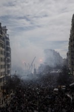 Tightly packed crowd under clouds of smoke on a city street MascletÃ¡ de Fallas