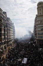Lively street with dense crowds and billowing smoke MascletÃ¡ de Fallas
