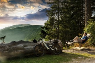 Cyclist enjoying the view from a bench on the Feldberg, Menzenschwand, Black Forest,