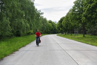 Cyclist on through road, cycle tour across military training area, Senne nature reserve, Teutoburg