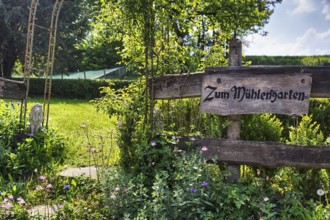 Wooden sign on the garden fence in summer, inscription, Zum MÃ¼hlengarten, country inn, historic