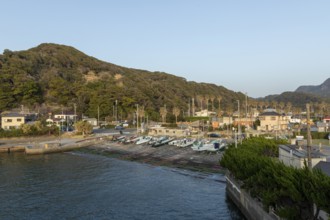Boats in the evening light and mountain landscape in the harbour of Hamakanaya, Futtsu, Chiba