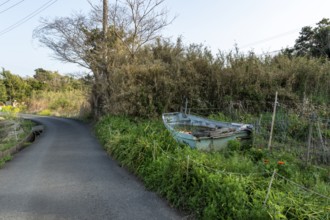 Old wooden boat on the side of a road in a rural landscape in the evening light, Hota, Kyonan,