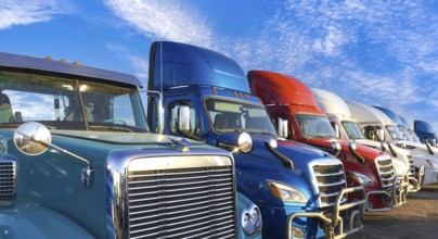 Long haul container trucks carrying commercial cargo on a parking lot ready for delivery