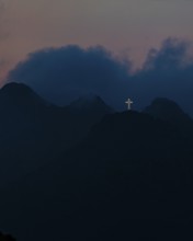 Illuminated steel cross on Monte Mar di Capanna, night shot, above Porto Azzurro, Elba Island,
