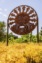 Rusty plaque with motif of the god of wine Bacchus, near the Arrighi winery, Porto Azzurro, Elba