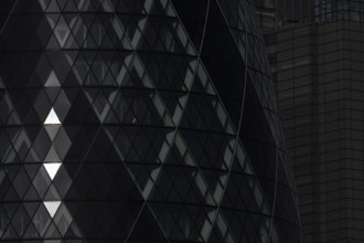 The Gherkin skyscraper building close up of window details with sunlight illuminating three