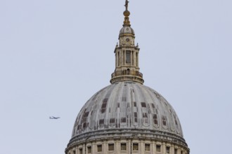 Dome of St. Pauls cathedral with a jet aircraft in the sky behind, City of London, England, United