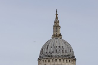 Dome of St. Pauls cathedral with a jet aircraft in the sky behind, City of London, England, United