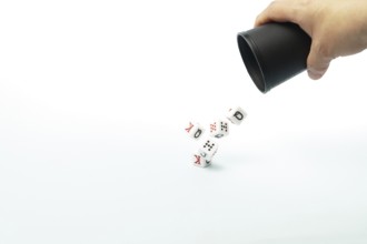 Poker dice falling from a black cup held by a hand, symbolizing risk, chance, and the thrill of