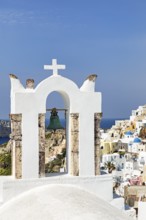 Bell tower of an orthodox church with a view of the village, Oia, Santorini, Cyclades, Greece