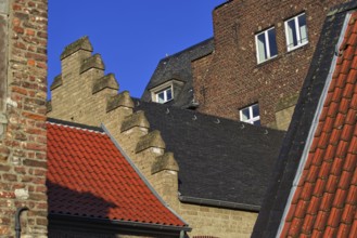 Different roof styles and brick wall under a clear blue sky, DÃ¼sseldorf