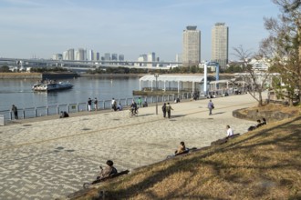 Strollers on the promenade and futuristic Tokyo Cruise Water Bus Queen Emeraldas, excursion boat