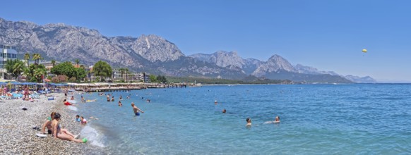KEMER, TURKEY - JULY 5, 2025 Kemer municipality public beach with vibrant pebble under a clear,