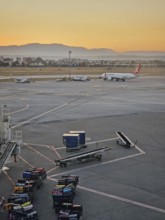 ANTALYA, TURKEY - JULY 5, 2025 Antalya airport scene at sunset with luggage being moved onto carts