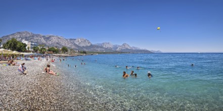 KEMER, TURKEY - JULY 5, 2025 Kemer municipality public beach with vibrant pebble under a clear,