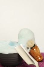 Shaving brush, straight razor, and shaving cream create a stylish and classic men's grooming scene