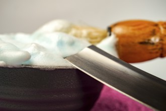 Shaving cream in bowl with straight razor and shaving brush, ready for barber to prepare customer
