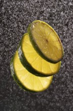 Three lime slices with drops of water