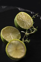 Three lime slices on a black stone plate