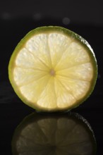 Slice of lime on stone slab with reflection