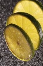 Three lime slices with drops of water