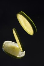 Three lime slices on a black background