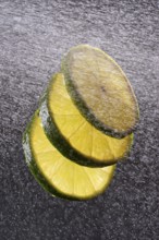 Three lime slices with drops of water