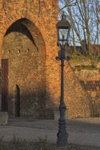 Classic lantern in front of historic brick building (Linn Castle gate) in the light show, Krefeld