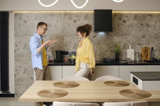 The husband explains his ideas to the young wife actively gesturing his hands during a conversation