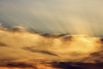 Sunset behind cloud cover, sunbeams, Oia, Thira, Santorini, Cyclades, Greece