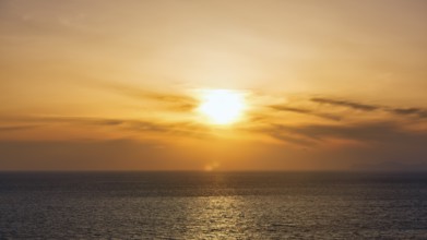 Evening sun behind Cirrus, golden sunset by the sea, Oia, Thira, Santorini, Cyclades, Greece