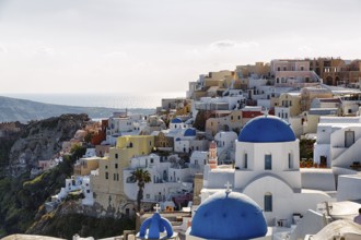 Typical architecture with white or colourfully whitewashed holiday homes and blue roofs, churches
