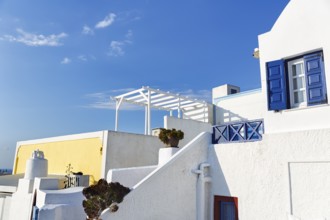 Architectural detail, typical white holiday homes, yellow wall, blue sky, Oia, Thira, Santorini,