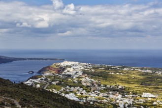Coastline with view of the village of Oia, hiker on hiking trail from Fira to Oia, Thira,