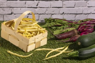 Vegetable mix of yellow beans, beetroot and courgettes on green grass