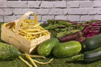 Vegetable mix of yellow beans, beetroot, cucumber and courgette on green grass