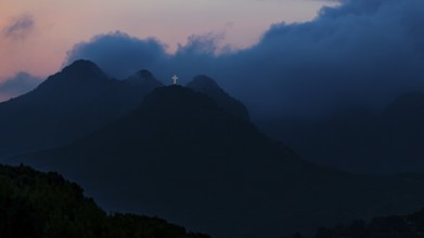 Illuminated steel cross on the summit of Monte Mar di Capanna, above Porto Azzurro, night shot,
