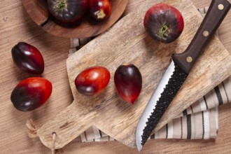 Sliced tomatoes, Black Beauty variety, on a cutting board, top view, on the kitchen table