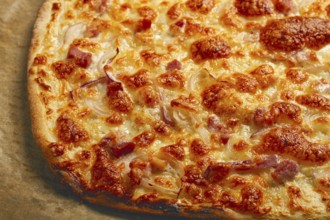 Tart flambe, open pie, rectangular pizza, with cheese and red onion, bacon slices, Alsatian dish,