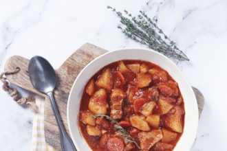 Meat goulash with potatoes and carrots, sweet peppers, in a saucepan, top view, traditional