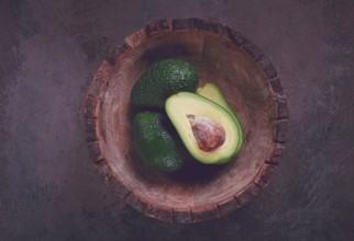 Fresh, sliced avocado, in a wooden plate, top view, food background, concept, food styling