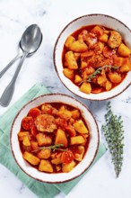 Meat goulash with potatoes and carrots, sweet peppers, in a saucepan, top view, traditional