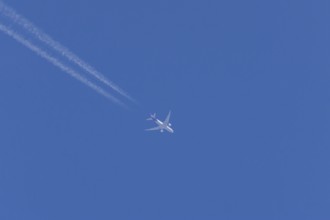 Airbus A300-600RF jet aircraft of FedEx Express airlines in flight in a blue sky with vapour trails