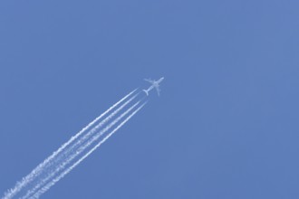 Airbus A340-300 jet aircraft of Lufthansa airlines in flight in a blue sky with vapour trails or