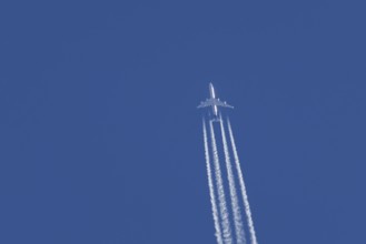 Airbus A340-300 jet aircraft of Lufthansa airlines in flight in a blue sky with vapour trails or