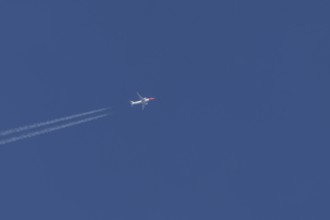Boeing 737 jet passenger aircraft of Norwegian Air airlines in flight in a blue sky with vapour